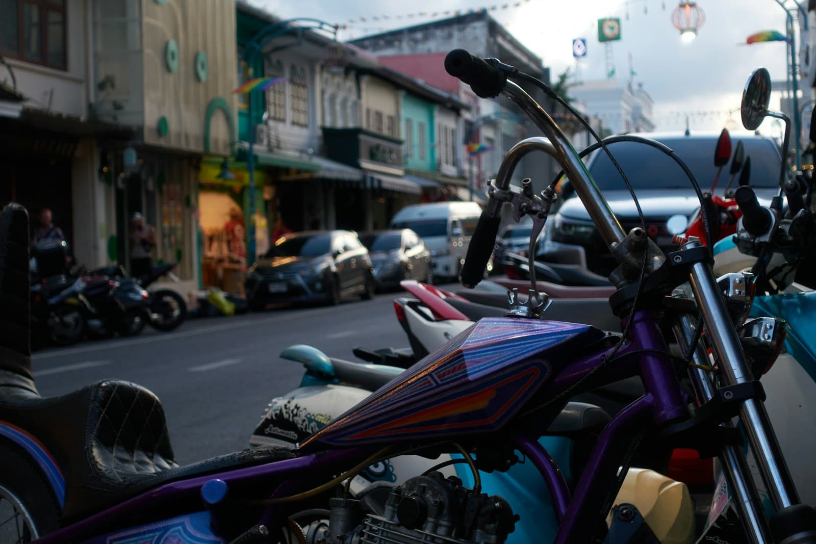 Custom motorcycles lined up along a street at a bike meet