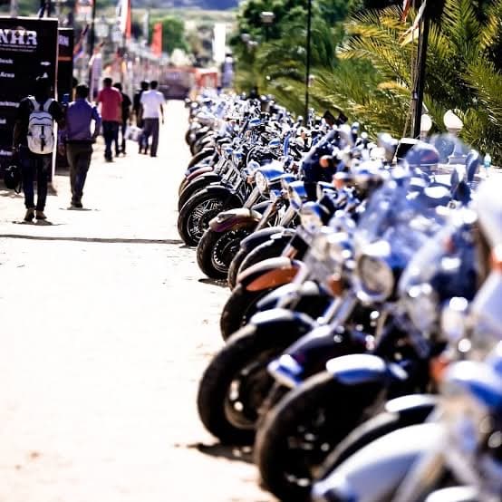 Rows of parked motorcycles stretching down a rally midway