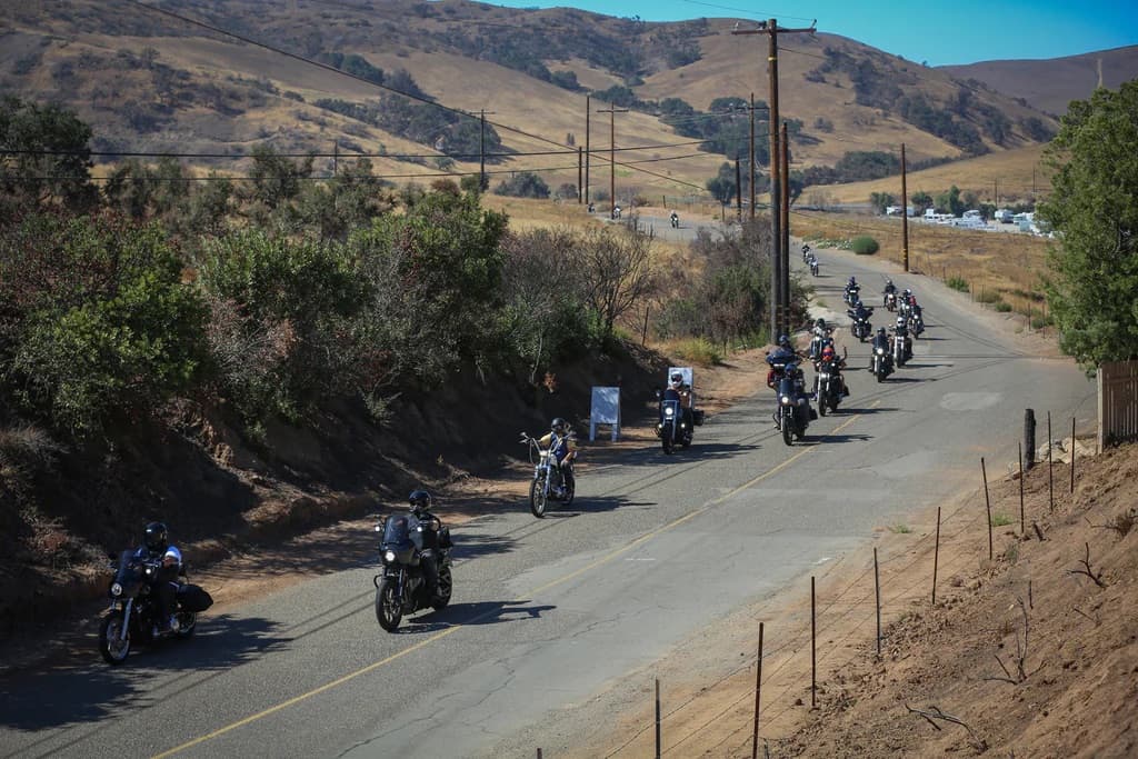 A group of riders rolling down a canyon road in single file