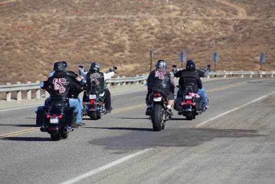 A riding club rolling through desert hills