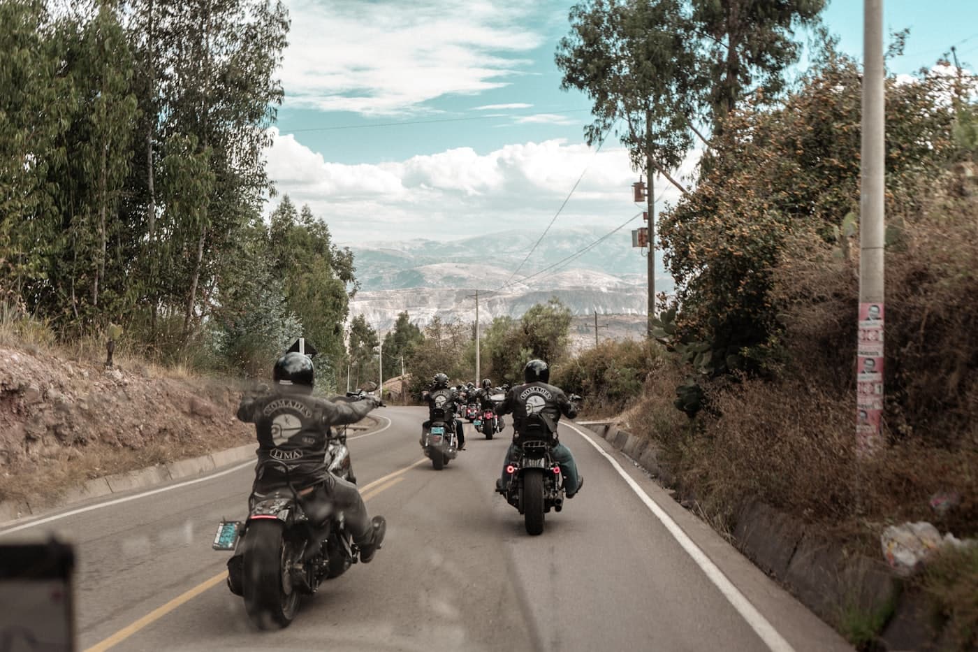 A riding club cruising a two-lane road through the hills
