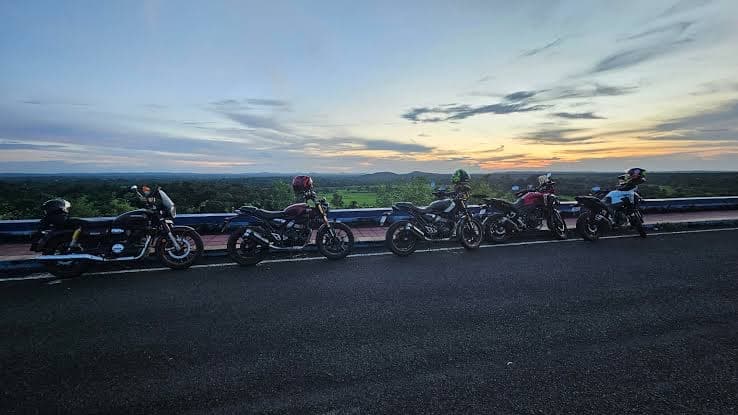 Five bikes lined up on an overlook at sunset