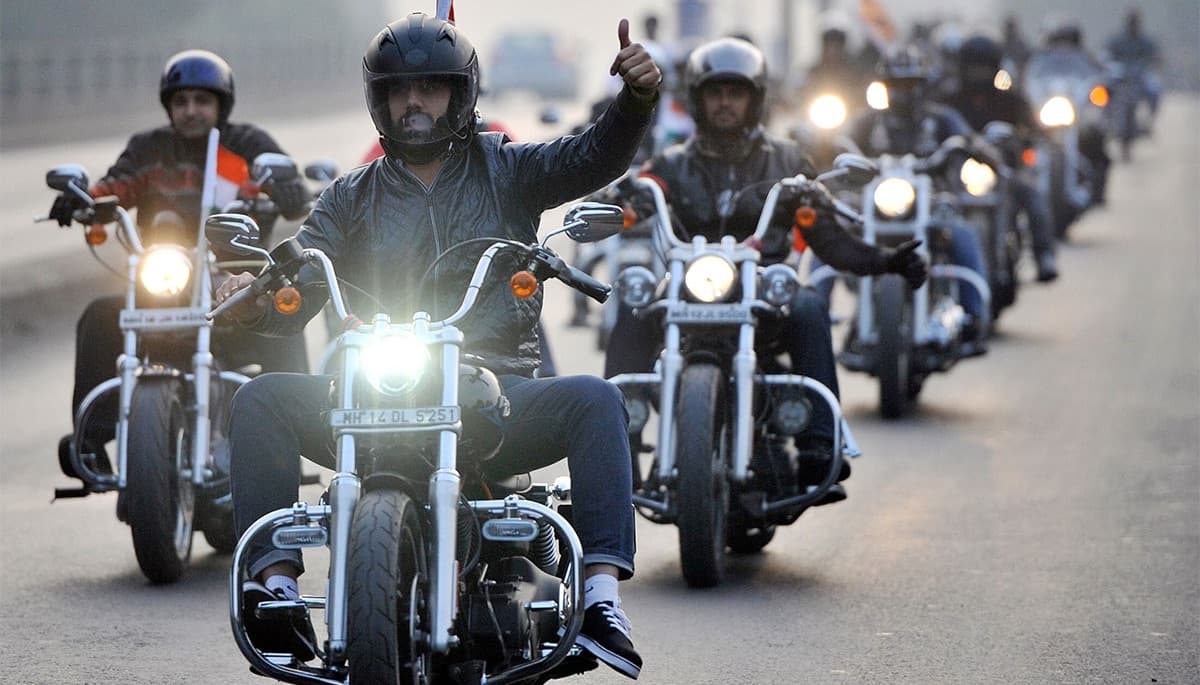 A rider throws a thumbs-up leading a group ride down the highway
